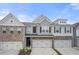 Stylish townhome boasts gray siding, brick accents, shutters, and two-car garage at 5365 Radford Loop, Fairburn, GA 30213