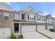 Attractive townhome showcases stone accents, gray siding, and attached two car garage at 5365 Radford Loop, Fairburn, GA 30213