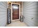 Front entrance with a dark wood door, a welcome sign, and exterior stone accents at 5365 Radford Loop, Fairburn, GA 30213