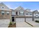 Stylish townhome front exterior with brick, siding, two-car garage, and driveway at 5365 Radford Loop, Fairburn, GA 30213