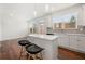 Modern kitchen with island, white cabinets, stainless steel appliances, and hardwood floors at 5365 Radford Loop, Fairburn, GA 30213