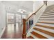 Open-concept living area features hardwood floors, fireplace, and elegant staircase at 5365 Radford Loop, Fairburn, GA 30213