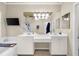 Bathroom featuring double sinks, a vanity area, a soaking tub, and a mounted television at 8555 Hope Mews Ct, Sandy Springs, GA 30350