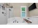 Bathroom with glass-enclosed shower, soaking tub and a bright window for natural light at 8555 Hope Mews Ct, Sandy Springs, GA 30350