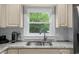 Kitchen featuring a stainless steel sink, granite countertops, and a window view at 8555 Hope Mews Ct, Sandy Springs, GA 30350