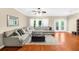 Spacious living room with hardwood floors, a ceiling fan, large sectional sofa, and natural light at 8555 Hope Mews Ct, Sandy Springs, GA 30350
