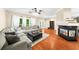 Open-concept living room with hardwood floors, a fireplace, a large sectional, and seamless transitions at 8555 Hope Mews Ct, Sandy Springs, GA 30350