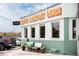 Charming exterior featuring a 'coffee, breakfast, lunch' sign, ample parking, and a small outdoor seating area at 964 Dekalb Ne Ave # 112, Atlanta, GA 30307