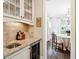 Bar area with glass cabinet and wine cooler that leads into a dining area with access to the backyard at 1014 Seaboard Nw Ave, Atlanta, GA 30318