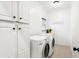 Clean laundry room featuring white cabinets and appliances, with a laundry motif at 1014 Seaboard Nw Ave, Atlanta, GA 30318