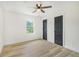 Bright bedroom featuring wood-look floors, ceiling fan, and view to a green space at 102 Aristocratic Way, Locust Grove, GA 30248