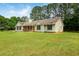 Charming single-story home with a welcoming front porch and a spacious green lawn surrounded by mature trees at 102 Aristocratic Way, Locust Grove, GA 30248