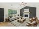 Bright living room featuring a stone fireplace, ceiling fan, and a large window with natural light at 102 Aristocratic Way, Locust Grove, GA 30248