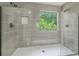 Elegant glass shower with large gray tiles, a window for natural light, and stylish fixtures at 102 Aristocratic Way, Locust Grove, GA 30248