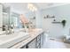 Bathroom with double sinks, decorative mirrors, granite countertop, and tiled floors at 1211 Fly Rod Ln, Loganville, GA 30052
