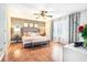 Spacious main bedroom featuring a ceiling fan, decor, hardwood floors, bench, and curtains at 1211 Fly Rod Ln, Loganville, GA 30052