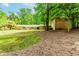 View of the home's backyard, featuring a brick exterior, mature trees and an outbuilding at 2228 Walker Dr, Lawrenceville, GA 30043