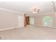 Spacious bedroom with built-in shelving, neutral carpet, fan and natural light from dual windows at 2228 Walker Dr, Lawrenceville, GA 30043