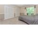 Cozy bedroom with neutral tones, carpet, and ample closet space, complemented by natural light streaming through the window at 2228 Walker Dr, Lawrenceville, GA 30043