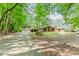 Charming home with a long driveway, attached garage, and inviting front porch surrounded by lush trees at 2228 Walker Dr, Lawrenceville, GA 30043