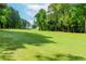 Green golf course view with a clear blue sky peeking through mature shade trees at 2228 Walker Dr, Lawrenceville, GA 30043