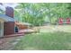 Backyard with wood deck, lawn, brick home, small storage shed, and mature trees at 2279 Parkview Cir, College Park, GA 30337