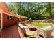 Backyard deck featuring cozy furniture with a lush green lawn and mature trees in the background at 2279 Parkview Cir, College Park, GA 30337