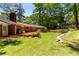Spacious backyard featuring a brick home, deck, mature trees, and a charming stone retaining wall at 2279 Parkview Cir, College Park, GA 30337