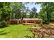 Expansive backyard with a well-maintained lawn, mature trees, and a charming brick home with deck at 2279 Parkview Cir, College Park, GA 30337