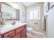 Bathroom with wood vanity, white sink and toilet, mirror, and updated fixtures at 2279 Parkview Cir, College Park, GA 30337