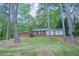 A single-story brick home nestled among mature trees on a well-maintained lawn at 2279 Parkview Cir, College Park, GA 30337