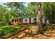 Single-story home with lush green lawn, mature trees, brick and white exterior, and a serene setting at 2279 Parkview Cir, College Park, GA 30337