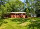 Charming single-story home with a brick facade, pristine lawn, and mature trees providing shade and privacy at 2279 Parkview Cir, College Park, GA 30337