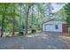 A single-car garage with white siding and a brick facade, surrounded by green trees at 2279 Parkview Cir, College Park, GA 30337