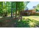 Backyard features a wooden deck connected to a brick home, surrounded by mature trees at 28 Indian Branch Way, Lawrenceville, GA 30043