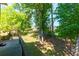 Spacious backyard bordered by mature trees, accessible from a wooden deck at 28 Indian Branch Way, Lawrenceville, GA 30043