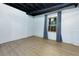 Partially finished basement with light wood flooring, window, and blue curtains at 28 Indian Branch Way, Lawrenceville, GA 30043