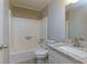 Bright bathroom featuring a shower-tub combo, granite countertop, and neutral tile at 28 Indian Branch Way, Lawrenceville, GA 30043