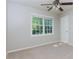 Cozy bedroom with a ceiling fan, neutral carpeting, and a bright window overlooking the backyard at 28 Indian Branch Way, Lawrenceville, GA 30043