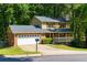 Charming two-story home boasts a brick front, attached garage, a welcoming porch, and a tree-lined yard at 28 Indian Branch Way, Lawrenceville, GA 30043