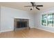 Bright living room featuring hardwood floors, a stone fireplace, a ceiling fan, and natural light from the windows at 28 Indian Branch Way, Lawrenceville, GA 30043
