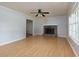 Spacious living room with hardwood floors, a stone fireplace, a ceiling fan, and large windows at 28 Indian Branch Way, Lawrenceville, GA 30043