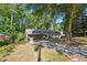 Exterior view of a charming home with mature trees, a driveway, green lawn, and an attached garage at 3708 Canadian Way, Tucker, GA 30084