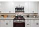 Kitchen with stainless steel appliances, gas range stove, granite countertops, and white cabinetry at 3708 Canadian Way, Tucker, GA 30084