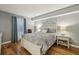 Calming primary bedroom with a large window, hardwood floors, a decorative headboard, and neutral grey colored walls at 407 River Mill Cir # 407, Roswell, GA 30075