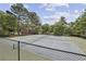 Outdoor tennis courts surrounded by mature trees and greenery on a sunny day at 407 River Mill Cir # 407, Roswell, GA 30075