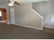 Spacious living room featuring neutral carpet, ceiling fan, and stairs to upper level, creating a welcoming atmosphere at 4368 Rocky View Dr, Forest Park, GA 30297