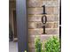 Close-up of the house number '101' on a brick exterior with some greenery in view at 101 Dewey Rd, Lilburn, GA 30047