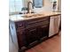 Kitchen island sink with granite countertops, dark cabinets, stainless steel dishwasher and hardwood flooring at 101 Dewey Rd, Lilburn, GA 30047