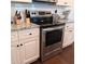 Stainless steel stove in modern kitchen with white cabinets, granite countertops, and white subway tile backsplash at 101 Dewey Rd, Lilburn, GA 30047